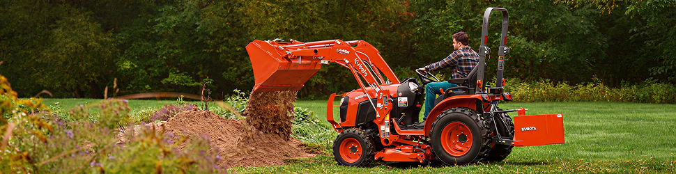 Kubota compact tractor scooping dirt